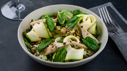 Fresh salad with zucchini, cabbage, guacamole, cucumbers, lettuce, spinach, green peas, flax seeds and pumpkin.