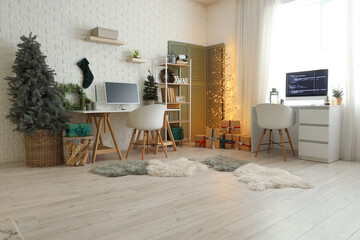 Interior of programmer's office with desks, Christmas trees and glowing lamp