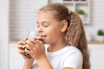 Cute girl drinking sweet hot cocoa in kitchen