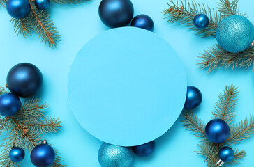 Composition with blank card, beautiful Christmas balls and fir branches on blue background