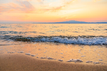 The ocean is calm and the sky is a beautiful orange color