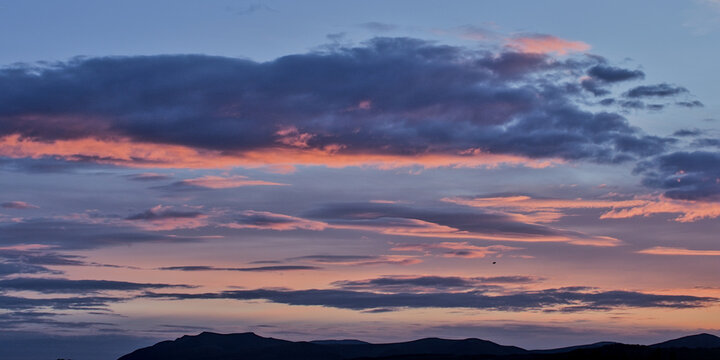 Clouds at sunset in blue and peach colors