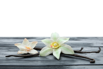 Aromatic vanilla pods and flowers on table against white background