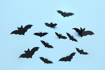 Many black paper bats for Halloween party on blue background