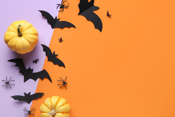 Paper bats with spiders and fresh pumpkins for Halloween party on colorful background