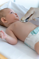 Woman pediatrician examining the baby with stethoscope during a checkup at clinic