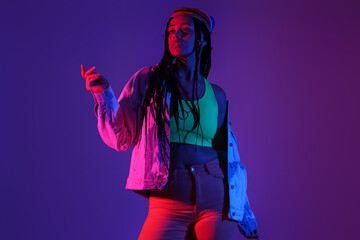 Beautiful young African-American woman with braids on color background