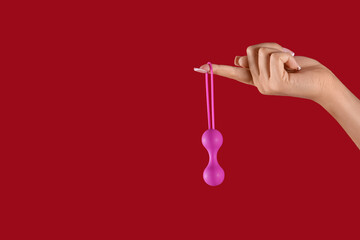 Woman with anal plug on red background
