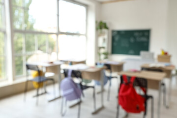 Blurred view of empty classroom with school desks