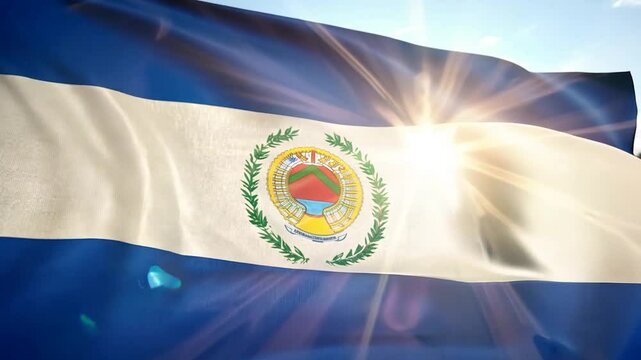 The vibrant flag of El Salvador displays the national emblem surrounded by laurel leaves, waving gracefully in the sunlight with a clear blue sky in the background