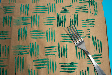 Fototapeta premium close up of decorative stamps with fork in the paint and sheets of paper. Create unique wrapping paper, DIY crafting project for personalized designs. Christmas activity for kids