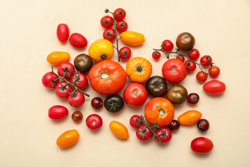 Different fresh tomatoes on beige background