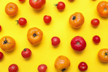 Different fresh tomatoes on yellow background