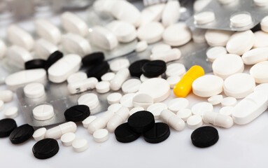 Closeup view of different pills spilled on white background. Medicine and pharmaceutics concept