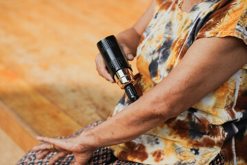 Fototapeta premium A close-up view of an individual using a tattoo machine on their arm, showcasing artistry and body decoration in a vibrant and colorful environment.