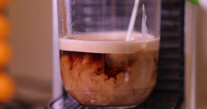 Watch as a coffee capsule is inserted into a sleek espresso machine, brewing a fresh shot of espresso, complete with aromatic steam