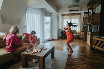 A mother and her two children engage in joyful playtime in a cozy living room. The scene captures a...