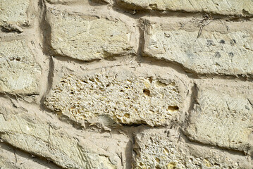 Old yellow wall made of natural stone blocks. A shell stone wall of an ancient building