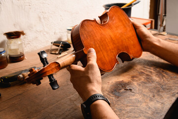 Detail of a luthier's hands using his tools