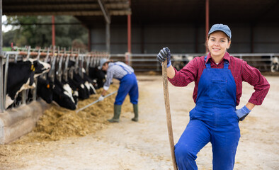 Portrait of confident successful european female farmer posing in cowshed
