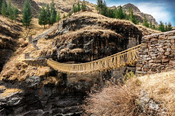 Puente de Queswachaca, puente incaico construido de paja andina en Cusco, Perú desde lejos con el...