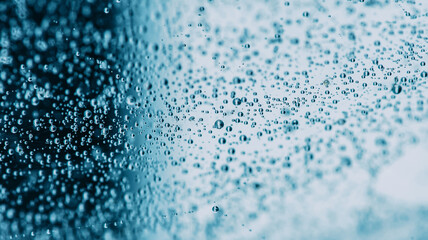 Macro photography showing tiny bubbles floating in blue liquid.