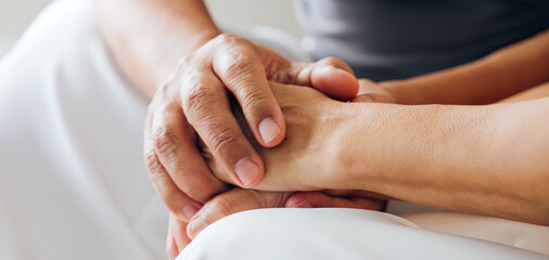Close up view of caring elderly grandma wife holding hand supporting senior grandpa husband give...