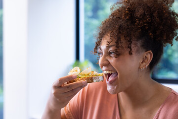 Eating healthy toast, woman enjoying nutritious snack in bright room, at home, at home