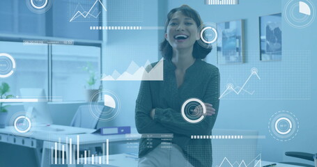 Businesswoman in office with data analytics and graphs image over workspace