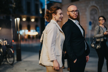 Fototapeta premium Business professionals walking confidently in the city at night, showcasing an urban lifestyle and blurred city lights.