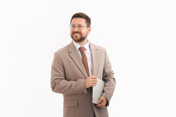 Portrait of smiling businessman with laptop on light background