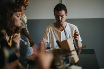 A group of young adults enjoying a casual meal together, sharing conversation and laughter in a relaxed and friendly atmosphere.