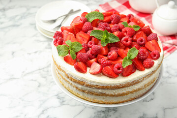 Tasty sponge cake with fresh berries and mint on white marble table, closeup