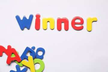 Word Winner made of magnetic letters on white background, flat lay