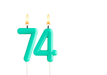 Green birthday candle on white background - Candle number 74