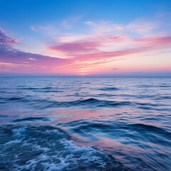 Obraz premium Tranquil ocean waves reflecting vibrant sunset hues at dusk by the serene coastline