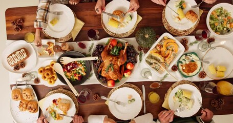 Dining table, food and hands of people at thanksgiving dinner with chicken, vegetables and juice. Meal, home and family at festive event, party or celebration gathering for supper from above.