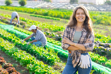 Girl is resting on garden field during work on harvesting from packaging of crop. Subsidiary farm,...