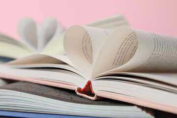 Books with wrapped pages on a pink background.
