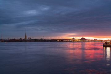 Fototapeta premium View of the Peter and Paul Fortress and the Neva River against a pink dawn sky with clouds on a sunny spring morning, St. Petersburg, Russia
