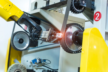 robotic arm handling the metal machined shaft parts polishing between the production line....