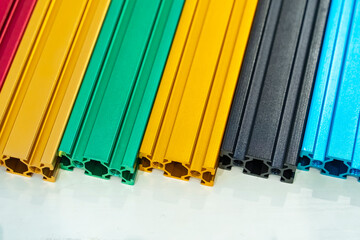 Various colorful samples of aluminum profile on the stand. Industry