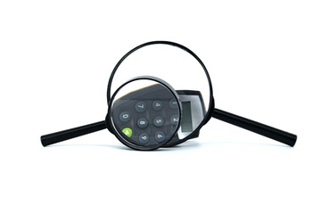 Magnifying glass focuses on calculator keypad symbolizing financial analysis, precision