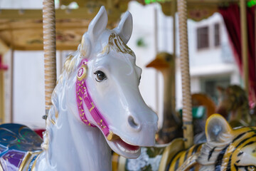Cute white carousel horse with pink harness