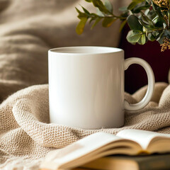 A white mug and book on a blanket