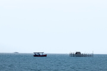 Bagan Apung with Fishing Boat in the Middle of the Ocean. Crystal Blue Seas Beneath a Bright and Clear Sky.