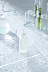 The minimalist skincare advertisement features a serum bottle on a glass plate with water droplets,...