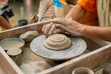 Close up of a potter's hands creating a ceramic vase on the craft wheel. © Sergio Palacio