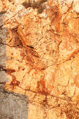 Sunlit rocky cliff with textured stone surface
