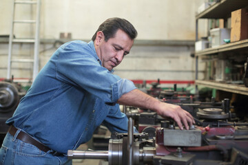 Mechanic adjusts lathe to grind brake disc